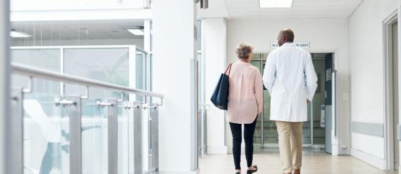 dokter en patiënt in ziekenhuisgang