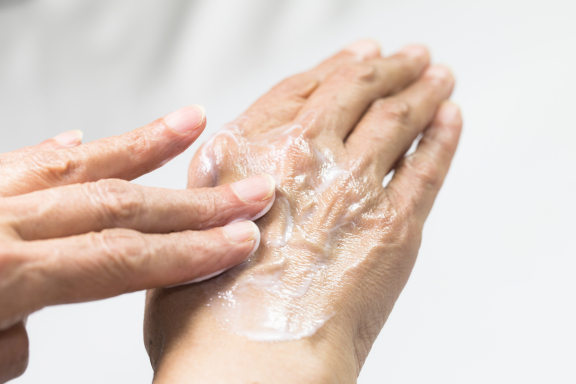 Persoon brengt crème aan op de handen