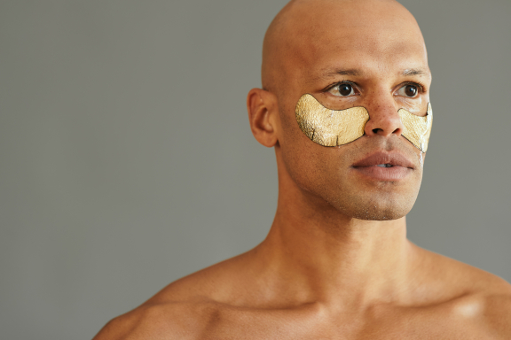 Jonge man met patches onder de ogen huidverzorging - iStockphoto