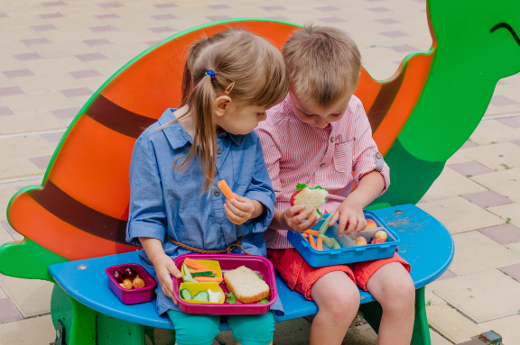 Twee kinderen met brooddoos met groenten en fruit - iStockphoto
