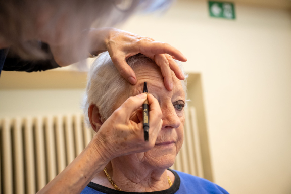Schoonheidsconsulente tekent wenkbrauw bij deelneemster workshop make-up en verzorging - Copyright: Joost Joossen