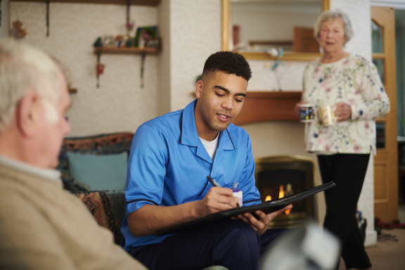 jonge arts of verpleger bij ouder koppel thuiszorg palliatieve zorg